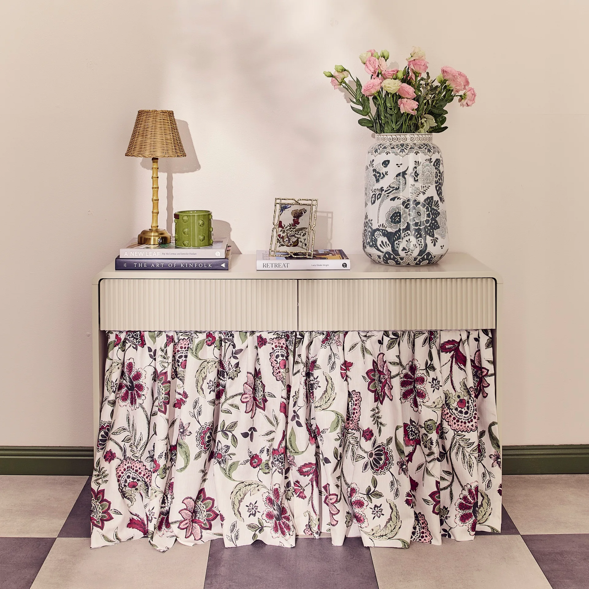 Floral fabric skirt on beige console with a styled tabletop