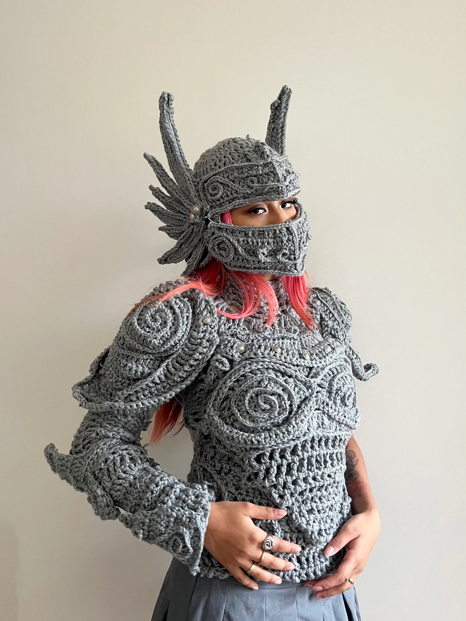 katelyn leonardo with crocheted armour in grey with pink hair showing underneath
