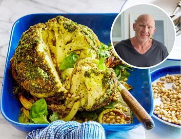 whole baked cauliflower with herby green butter on top, on a blue roasting dish with tea towel on handle. headshot of matt moran in circle in the corner