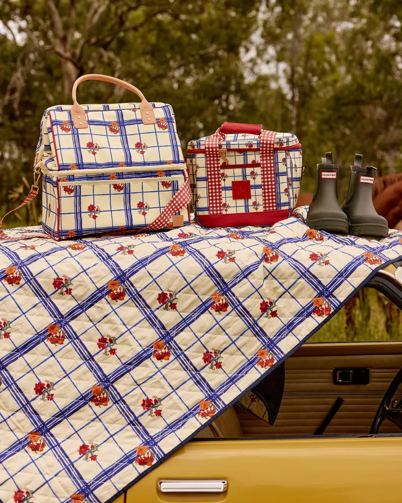 The Gatherer Picnic Rug from Somewhere Co, laid across the hood of a bright yellow car