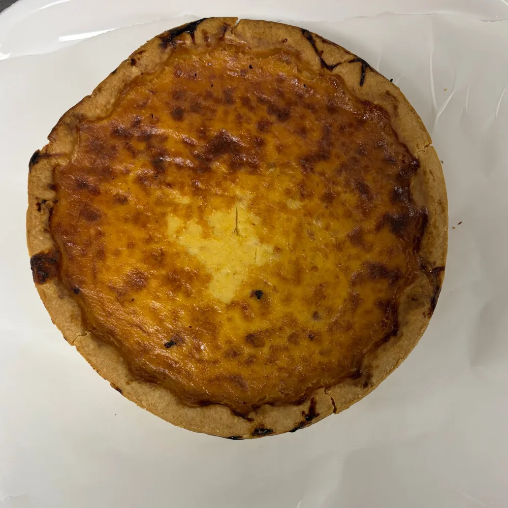 hedys quiche lorraine with thick crust and browned top sitting on white tray