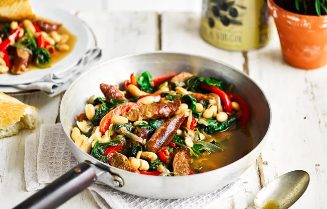 Beef sausages served with cannellini beans and vegetables
