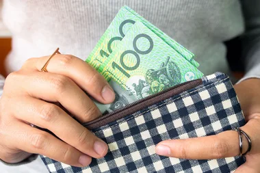 Hand holding hundred dollar notes in wallet.