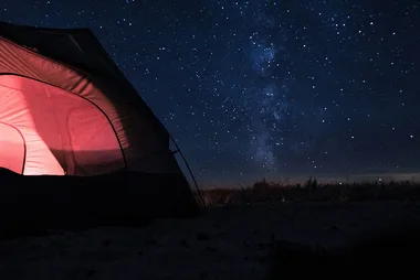 Nighttime camping scene in a tent using gear with a BCF discount code