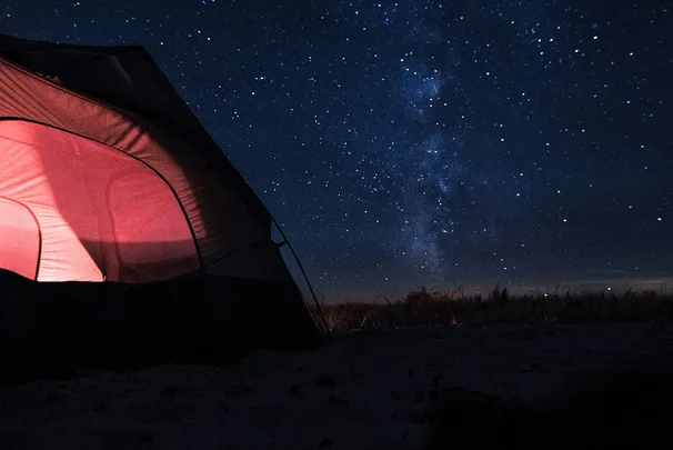 Nighttime camping scene in a tent using gear with a BCF discount code