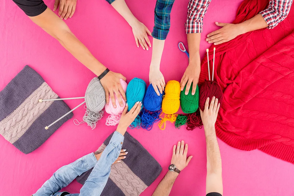 Arms reaching for knitting yarn