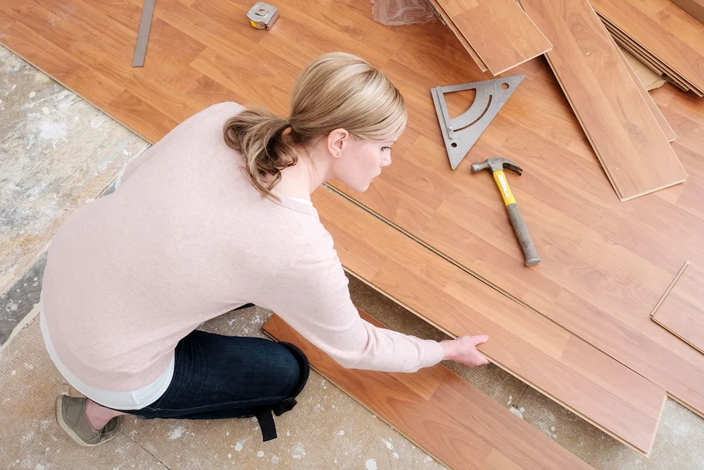 Woman installing laminate flooring