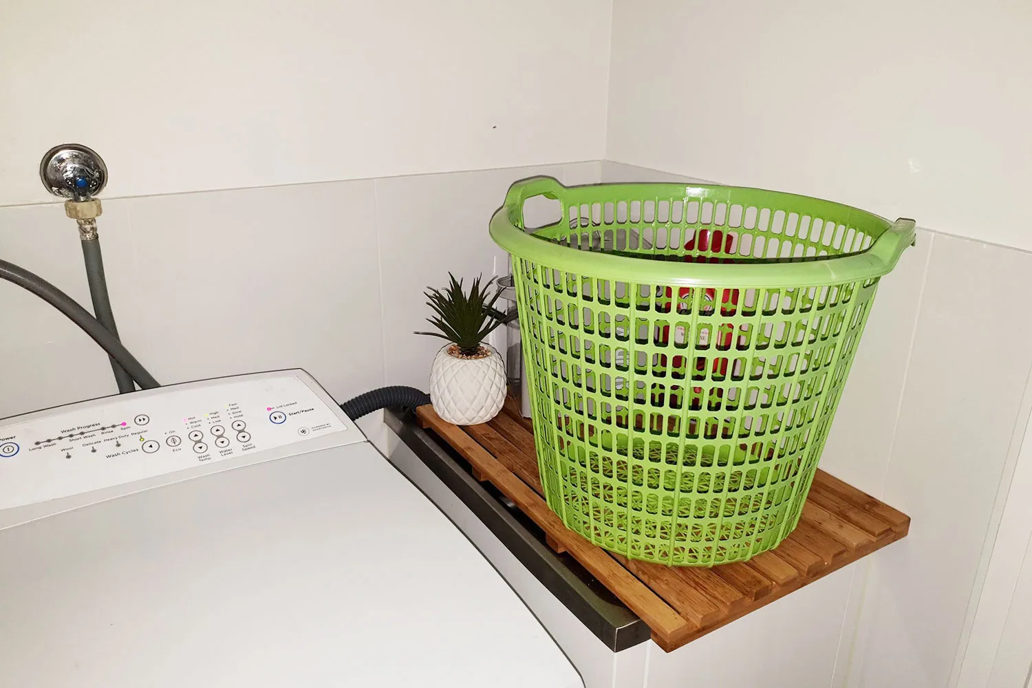 The Kmart duck board being used as a laundry sink cover is a cost-effective and stylish hack.