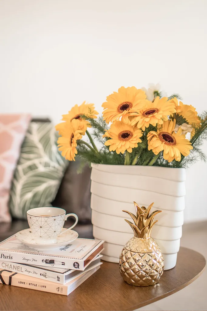 sun flowers in white vase with books