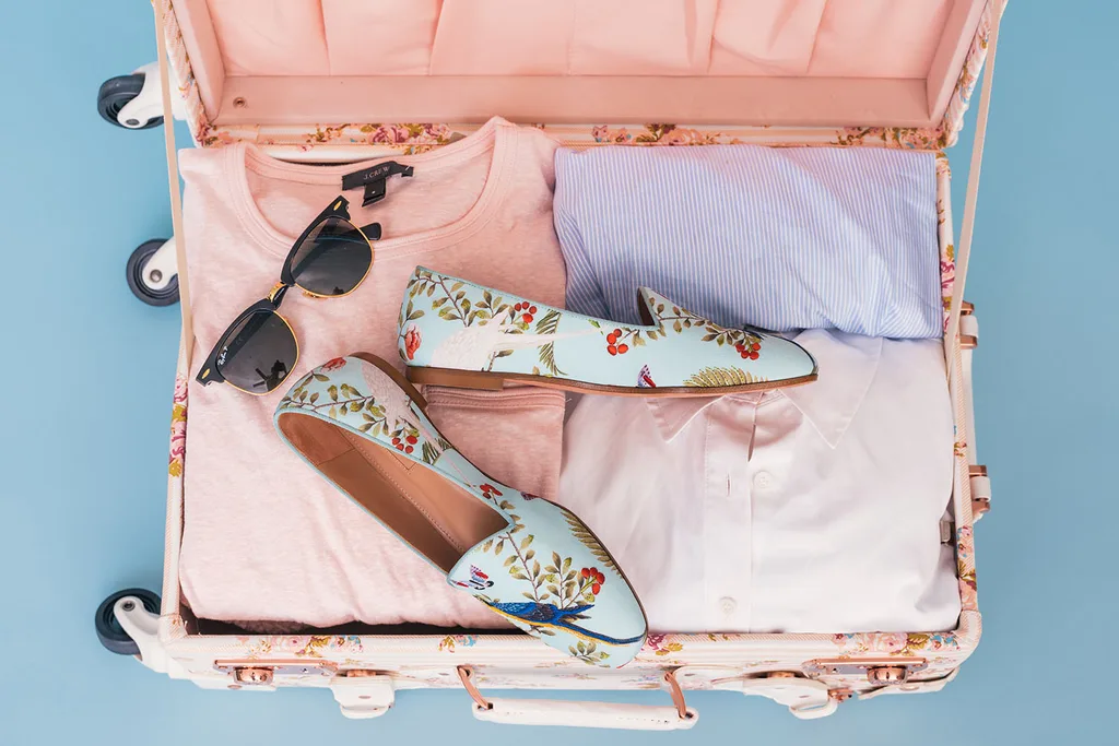 Flat lay pink suitcase packed