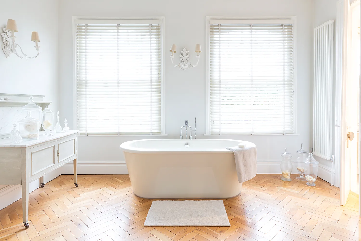 white bathroom with timber parquet flooring and stand alone bath
