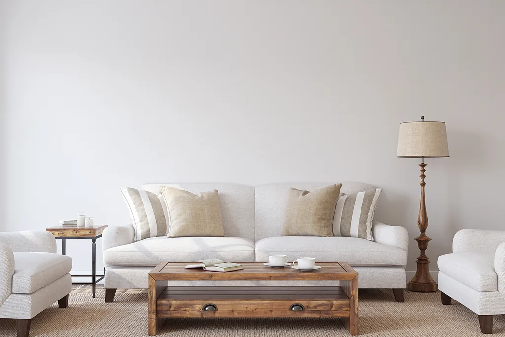 white living room with white furniture and beige rug ad wooden accents
