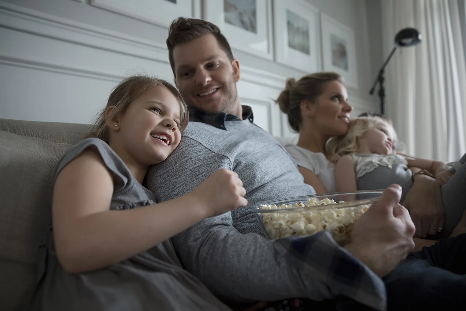 family eating popcorn on sofa