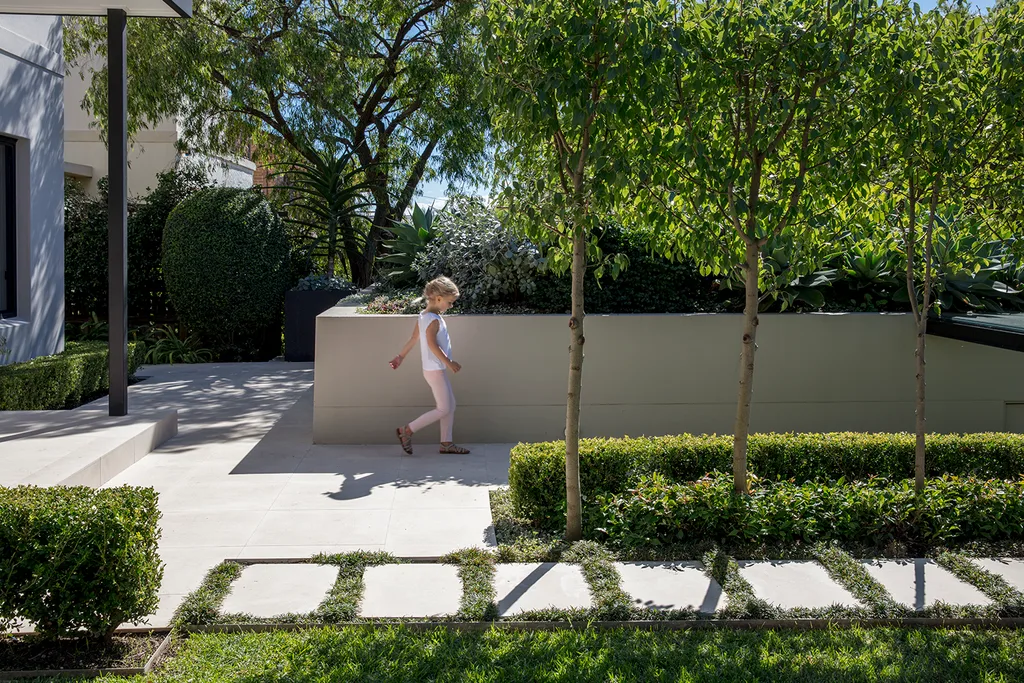 child walking on white pavers in garden