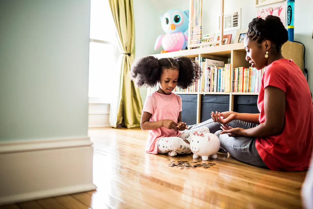 Mother teaching daughter about money sitting on floor