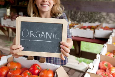 girl holding sign with organic written on it