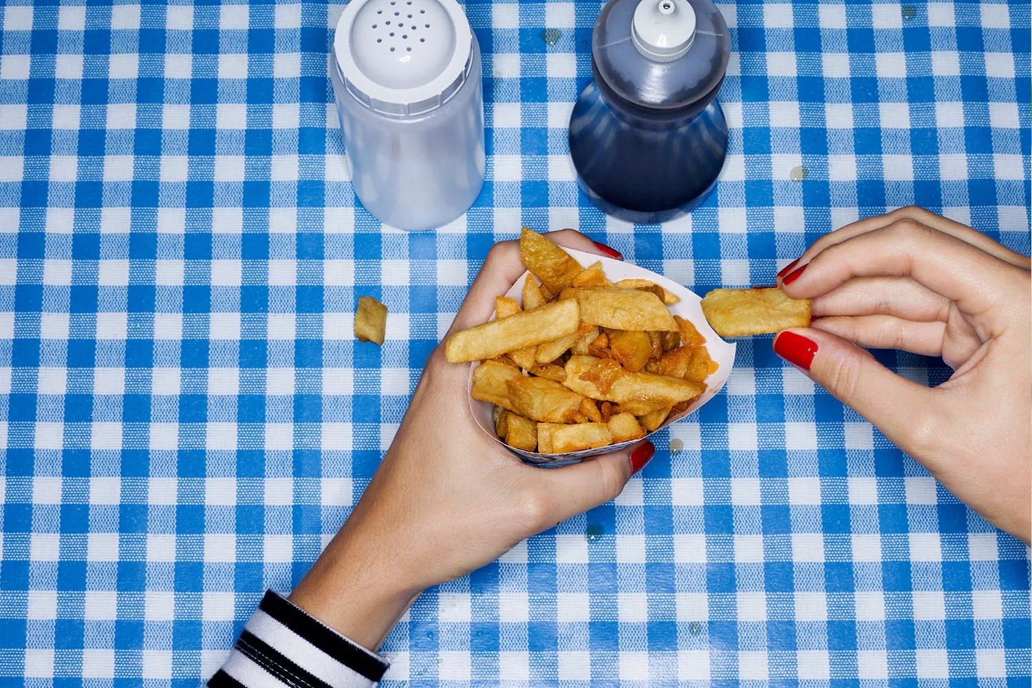 hot chips wit salt on blue checked table cloth