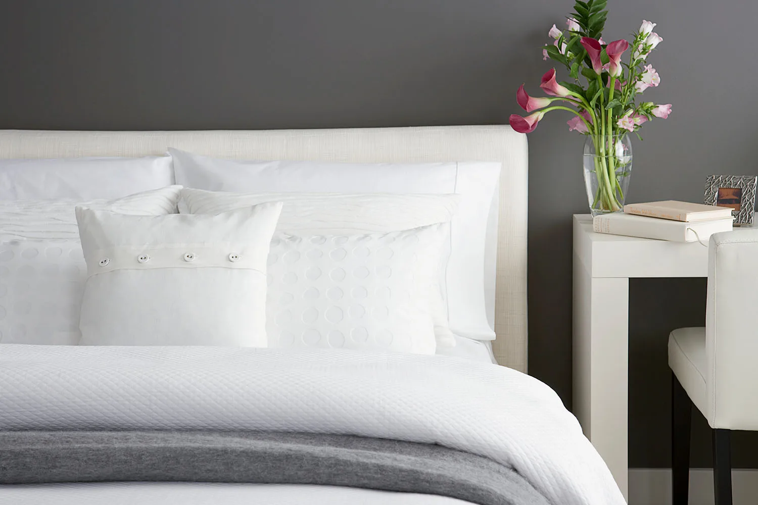 bedroom with white linens and flowers