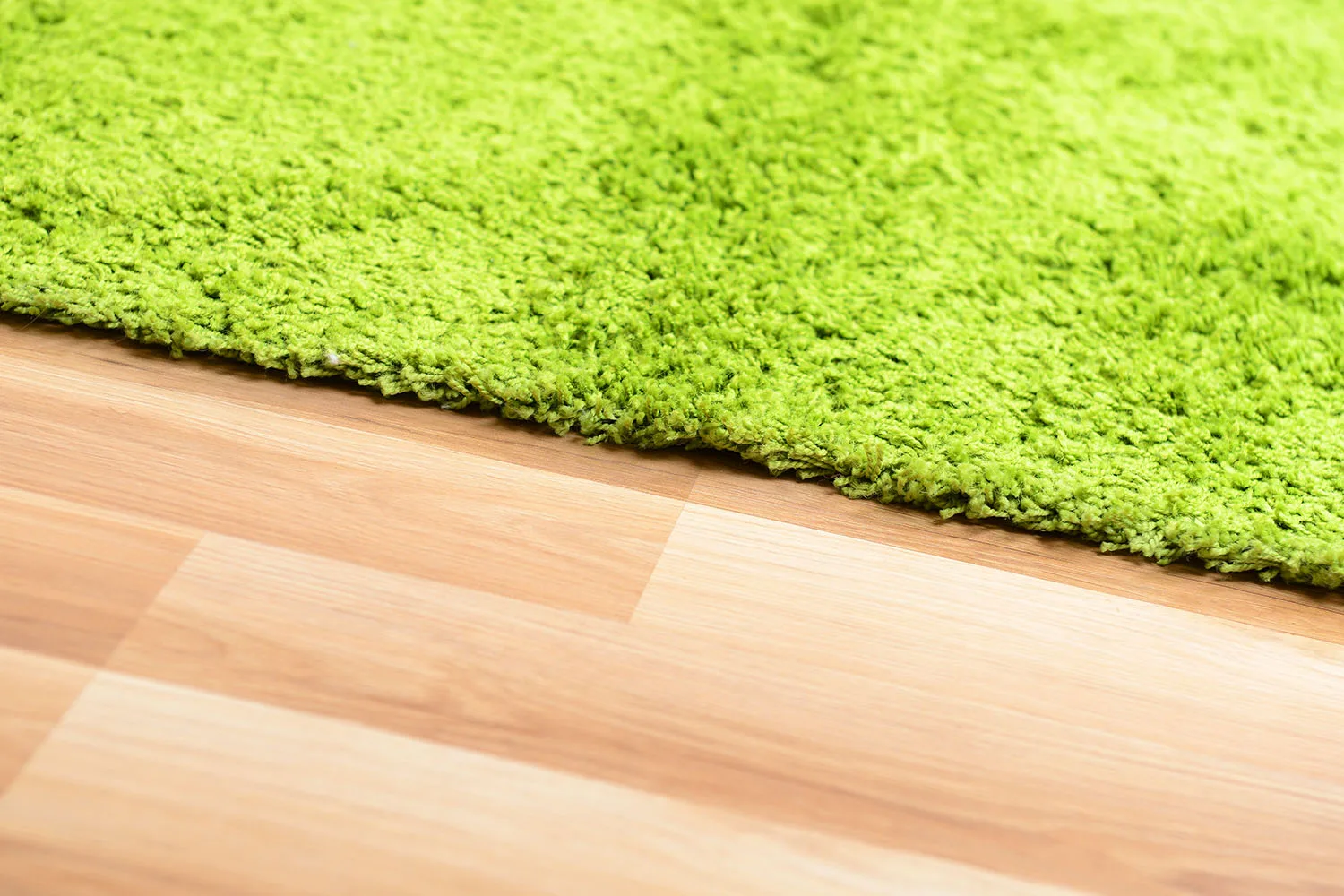 green rug on timber floorboards