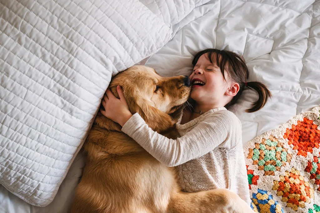 girl with dog in bed