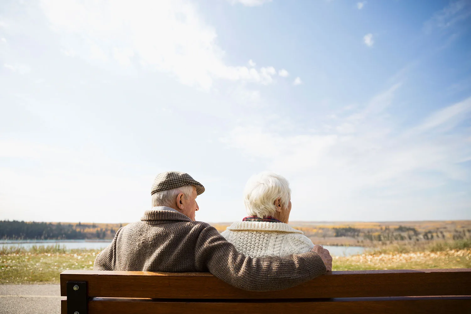 old couple sitting on park bench