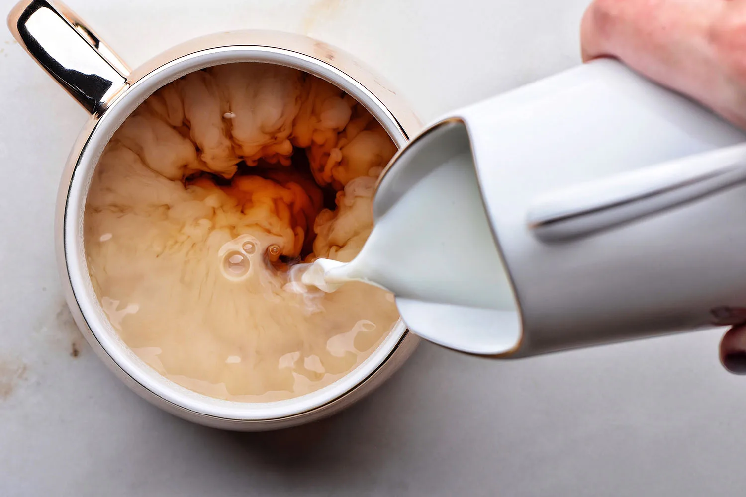pouring milk into coffee
