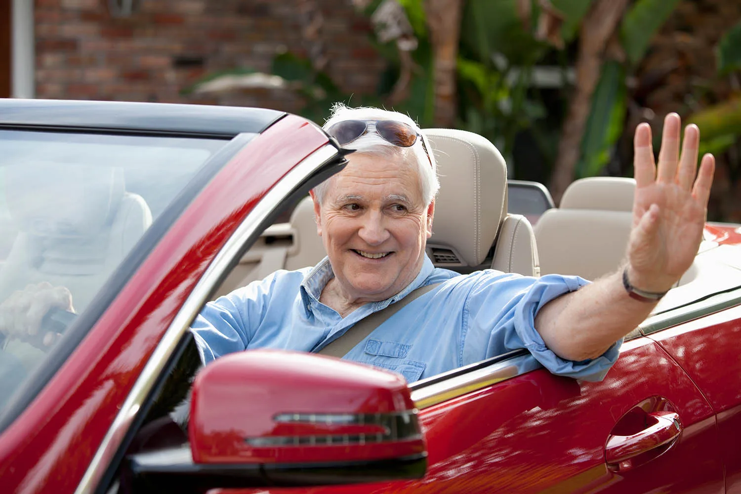 man waving from car