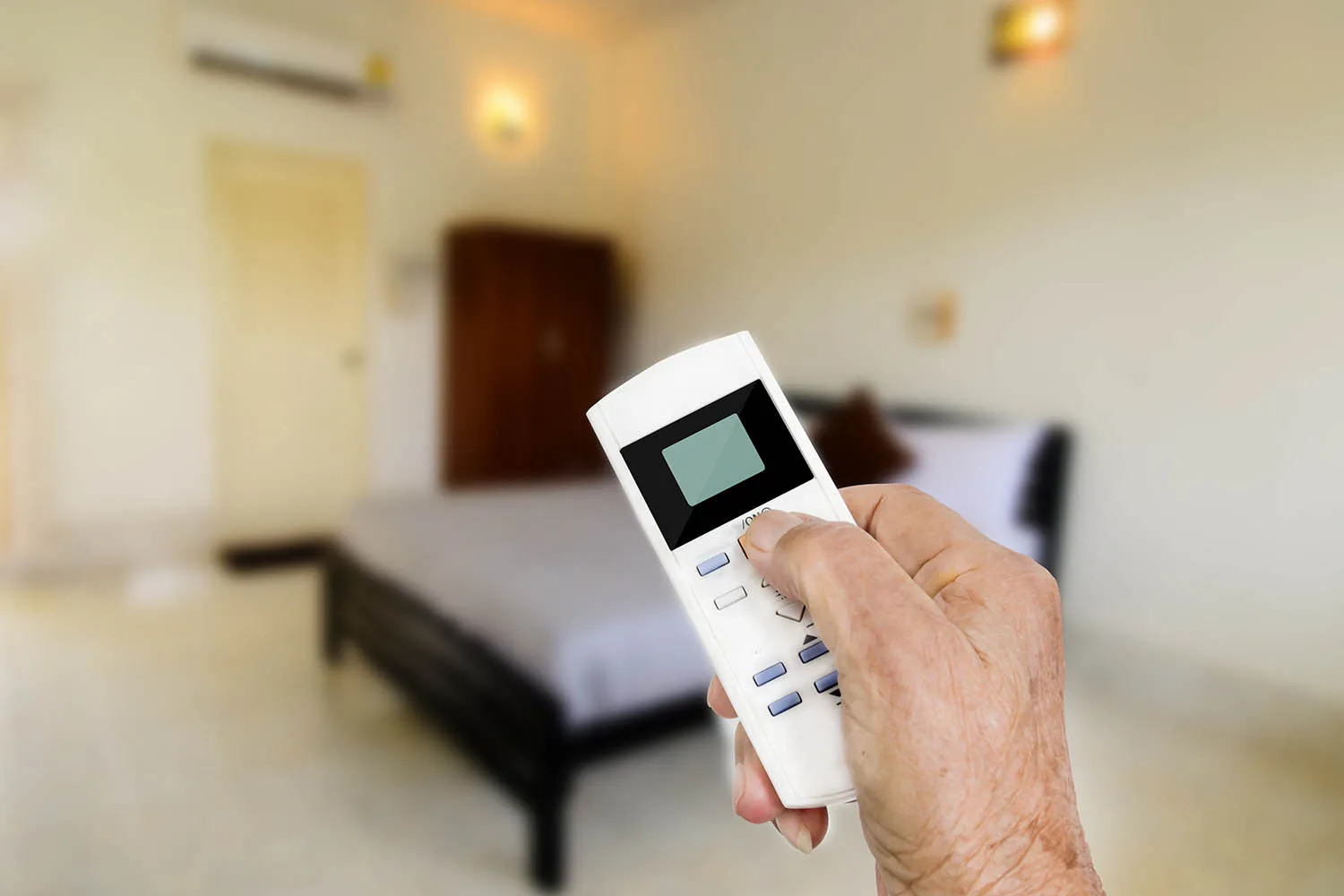 hand holding remote control to aircon unit