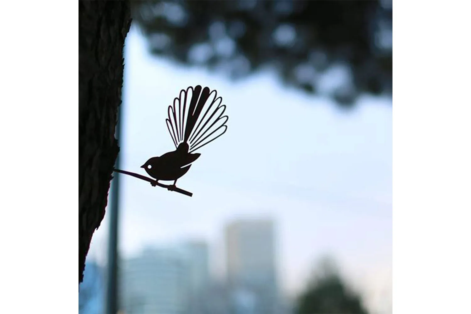 Fantail bird sculpture in tree
