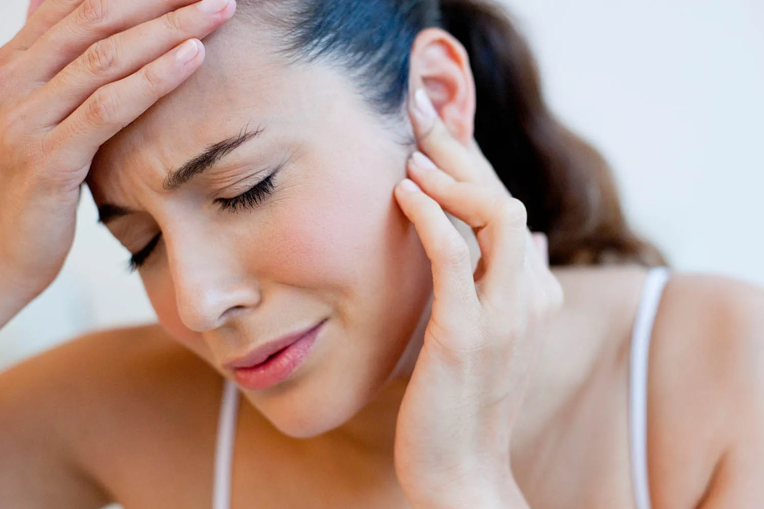 woman holding ear