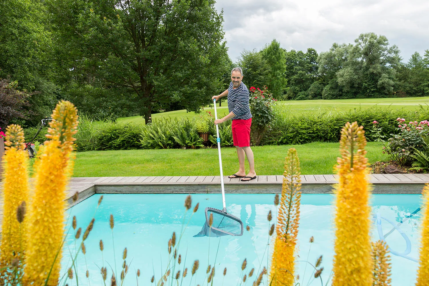 man cleaning pool