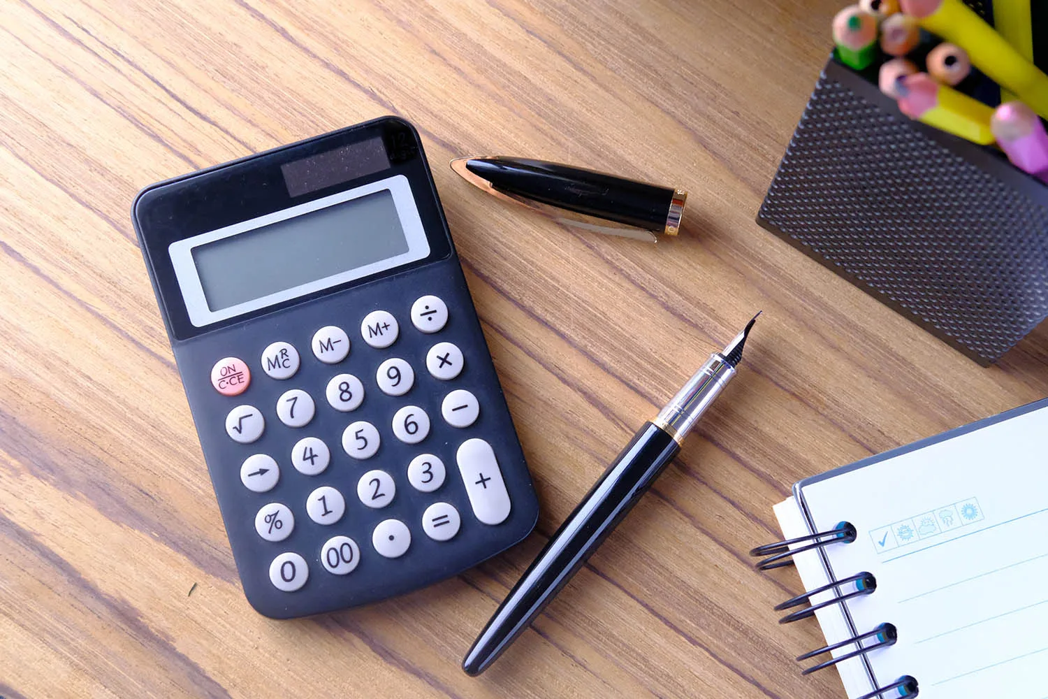 calculator and pens on table