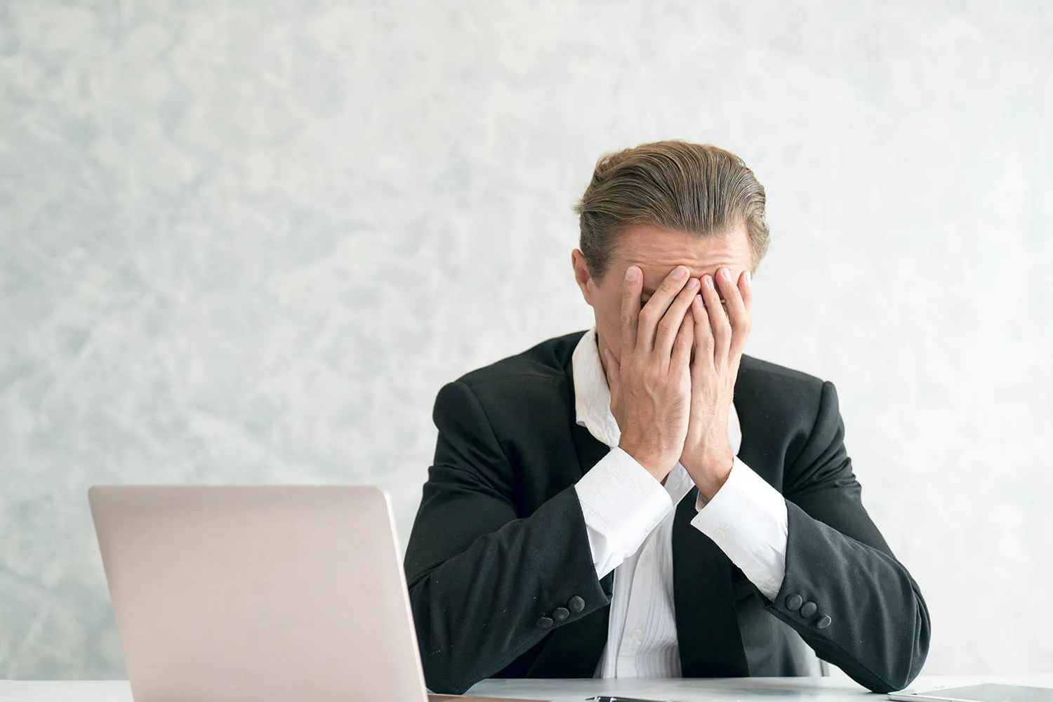 man covering face with hands