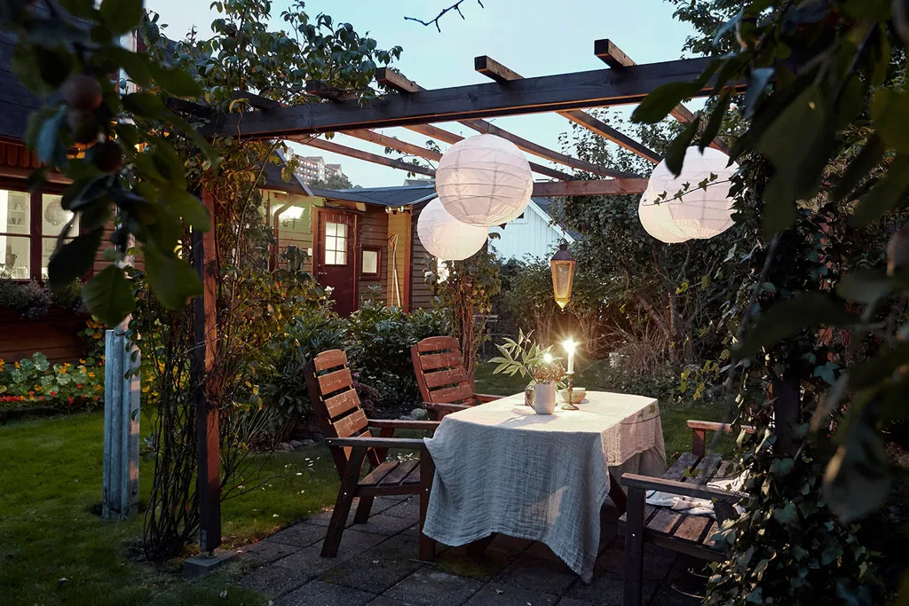 traditional pergola with lights and climbing plants