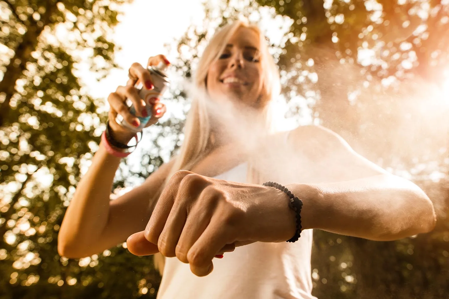 woman spraying insect repellant