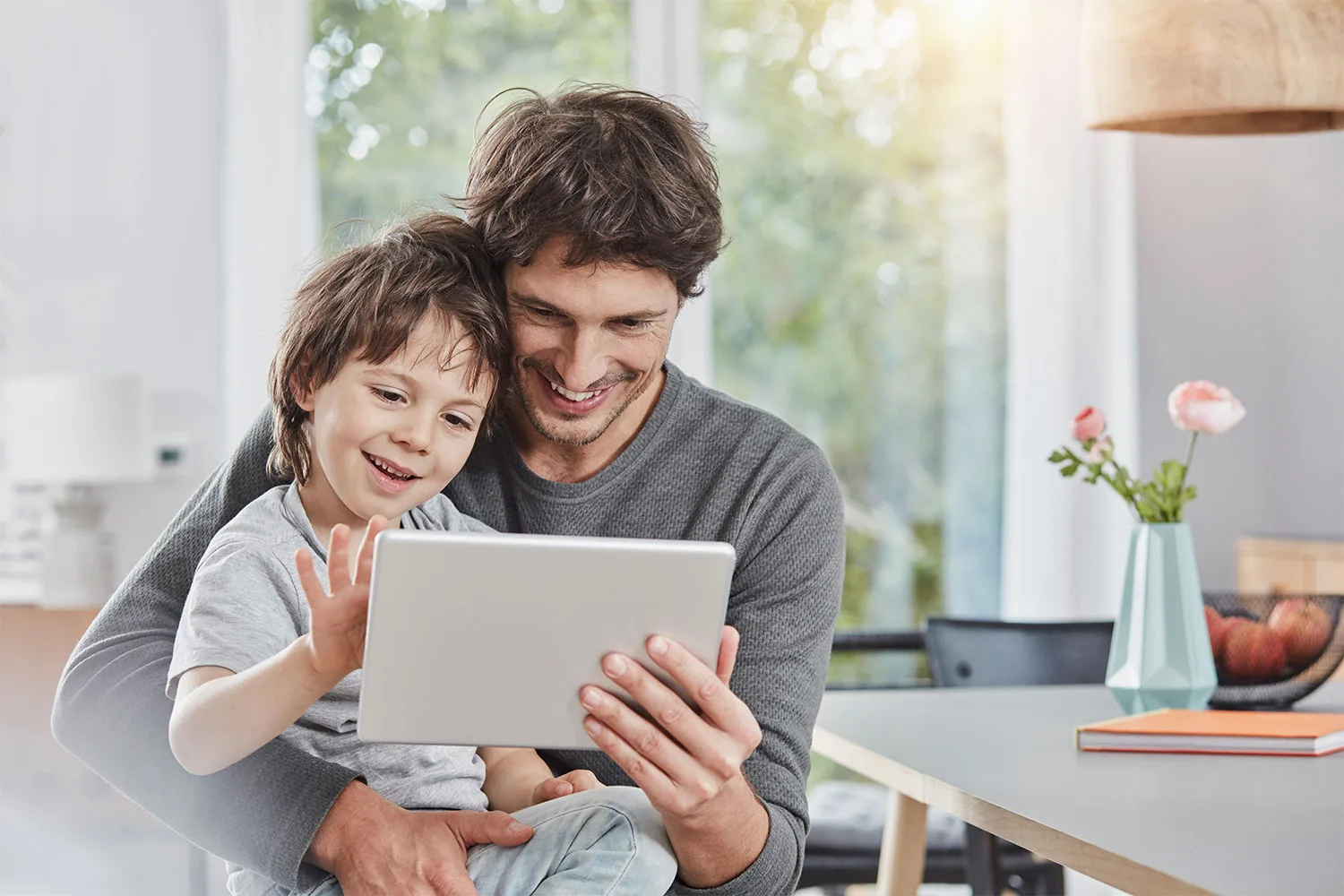 Father and son using ipad together