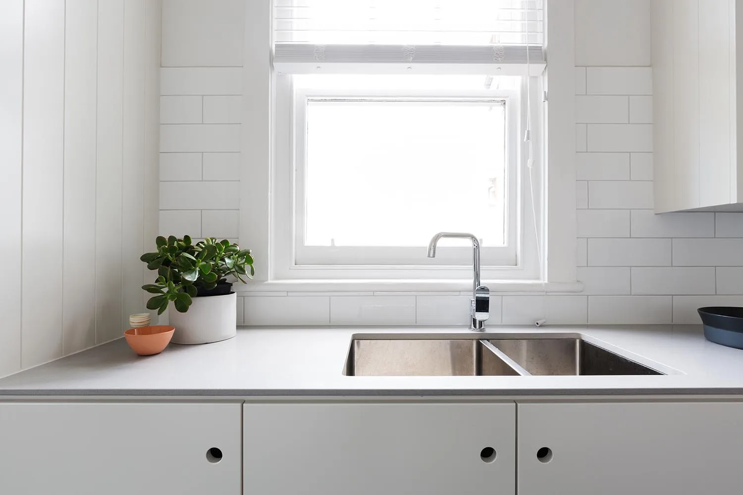 small kitchen sink and benchtop under window