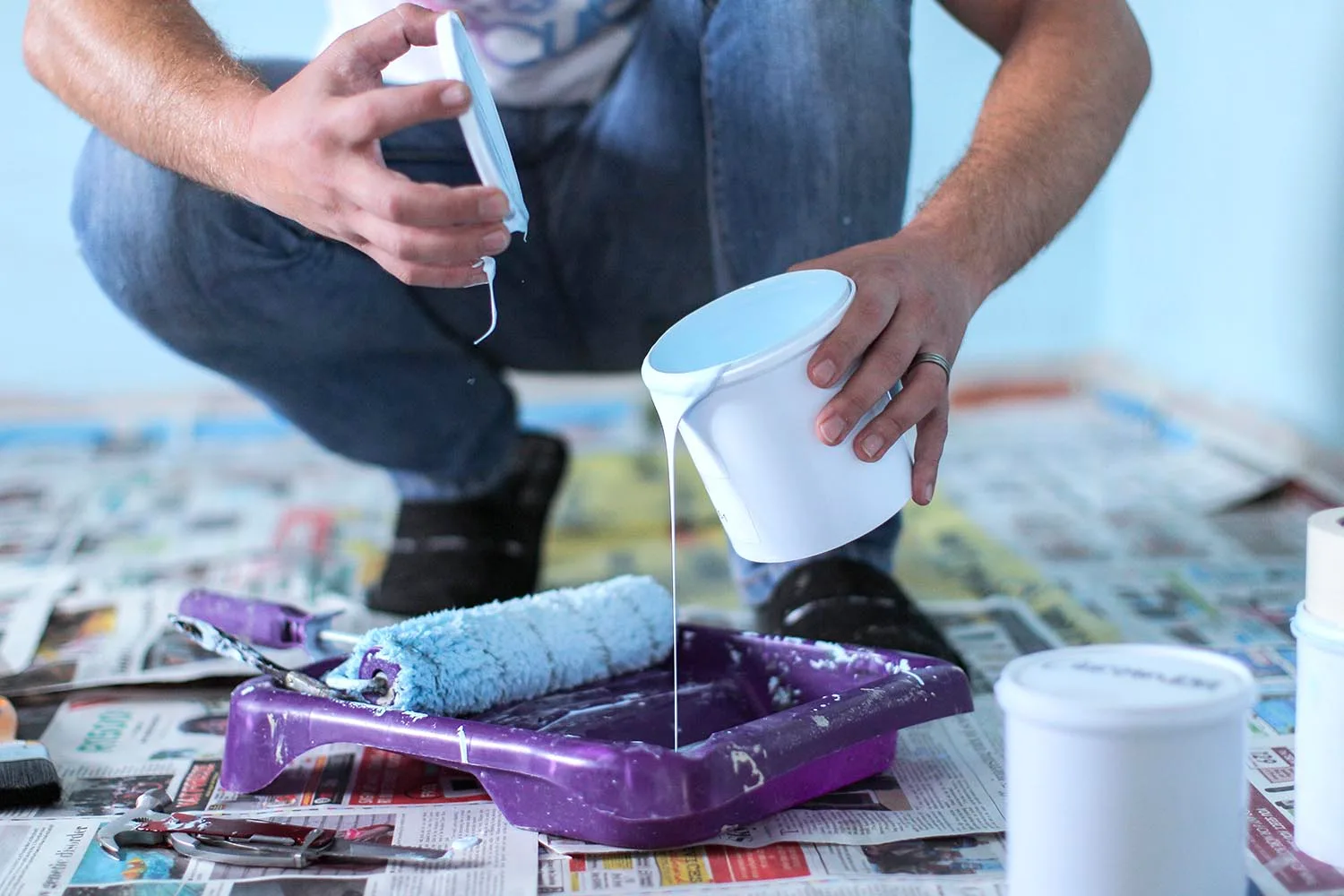 man pouring paint into tray