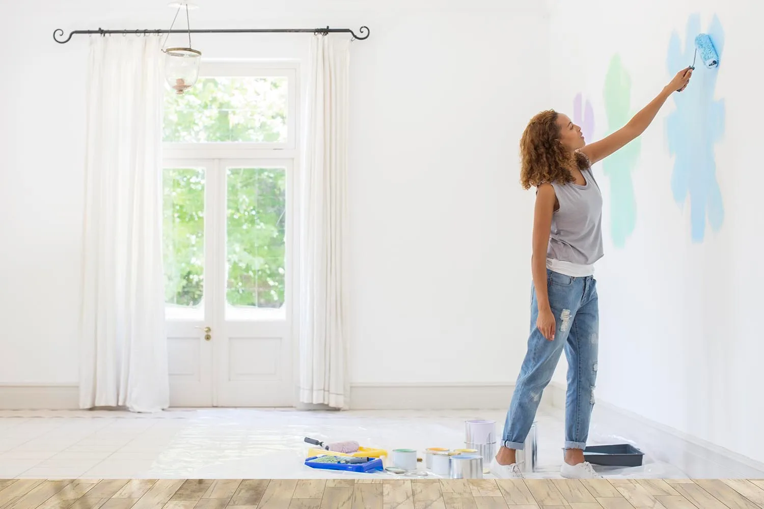 woman painting test swatches of paint on wall