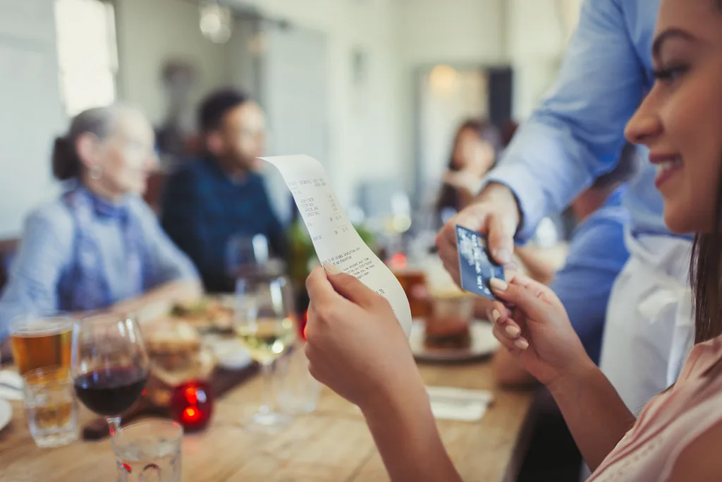 woman holding dinner bill
