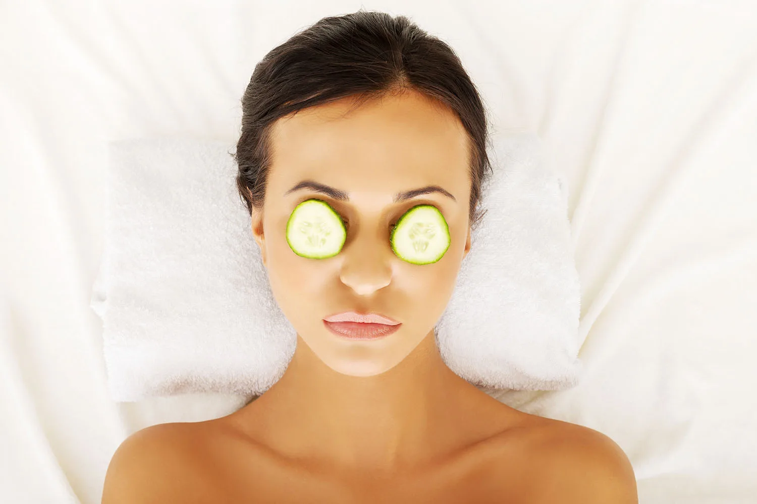 woman with cucumber slices on eyes