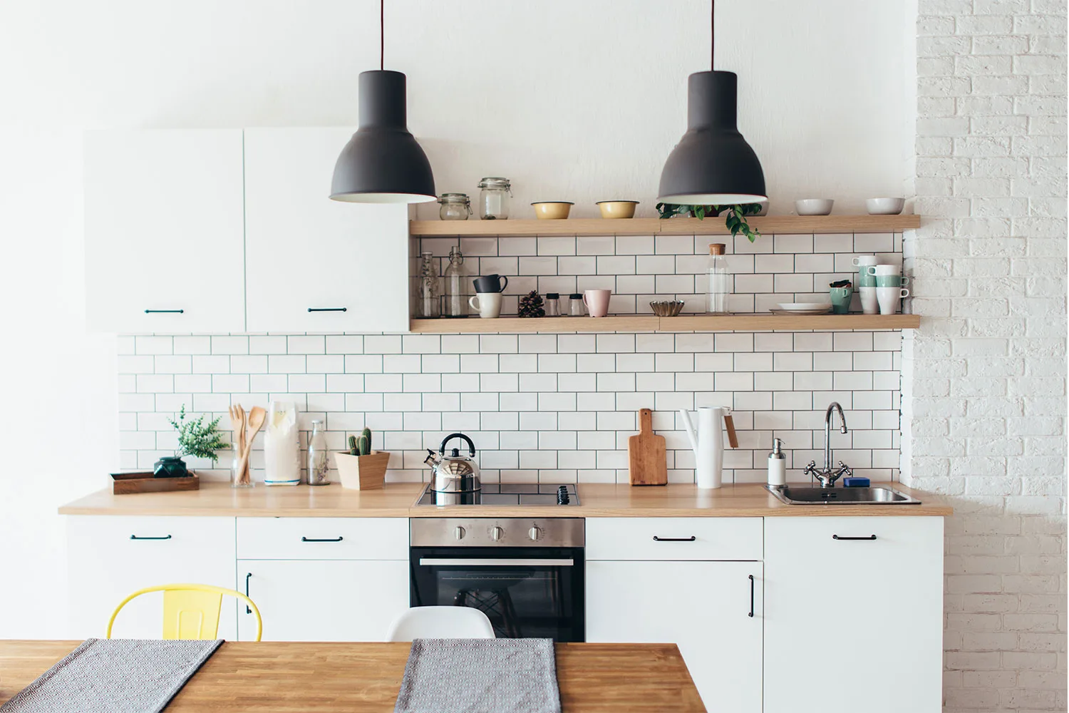 white kitchen with timber bench top and subway tiles