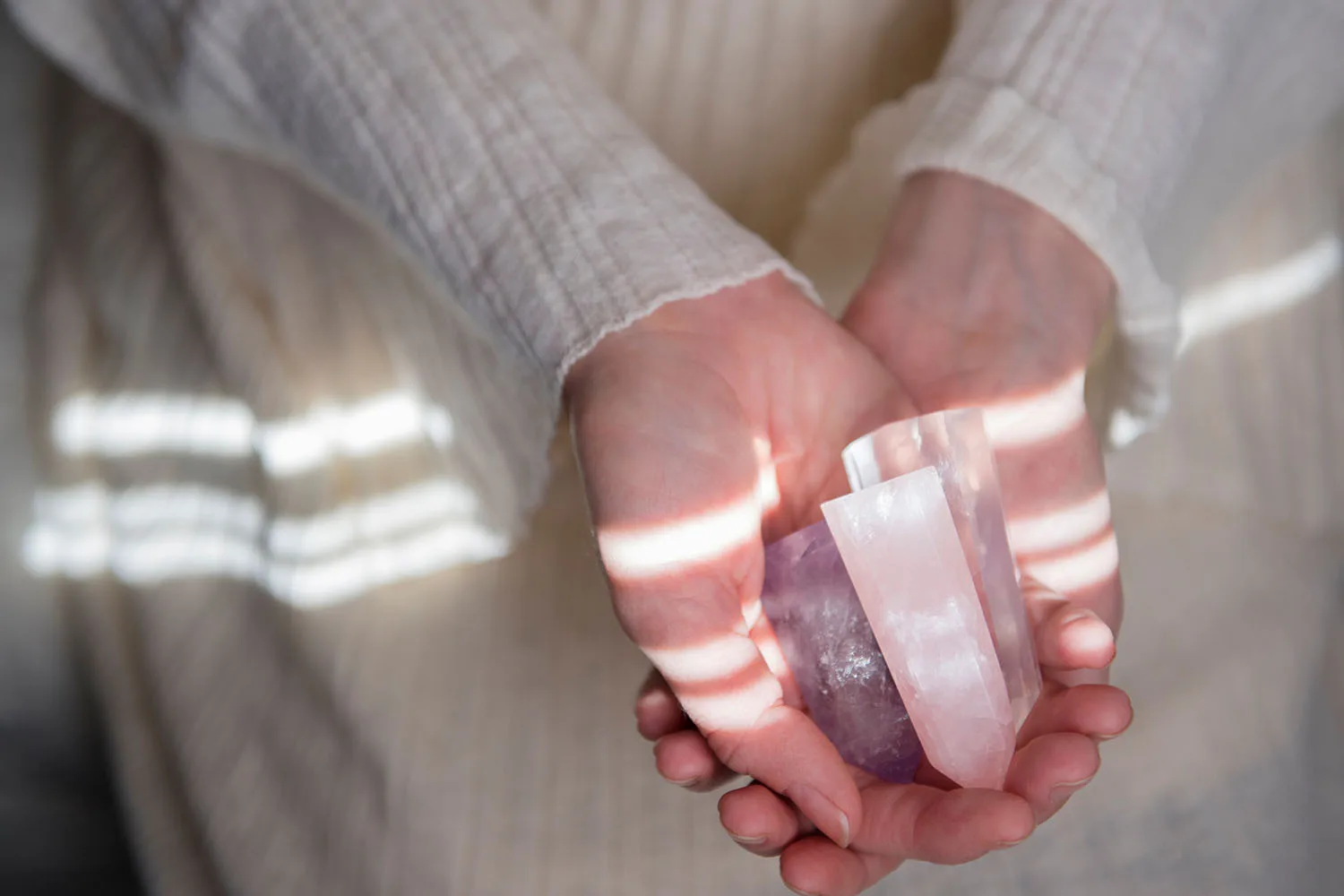 hands holding pink crystals