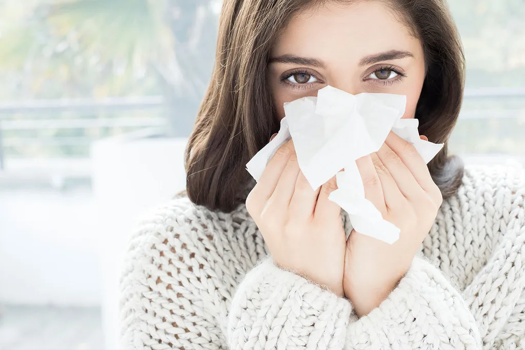 woman holding tissue to face