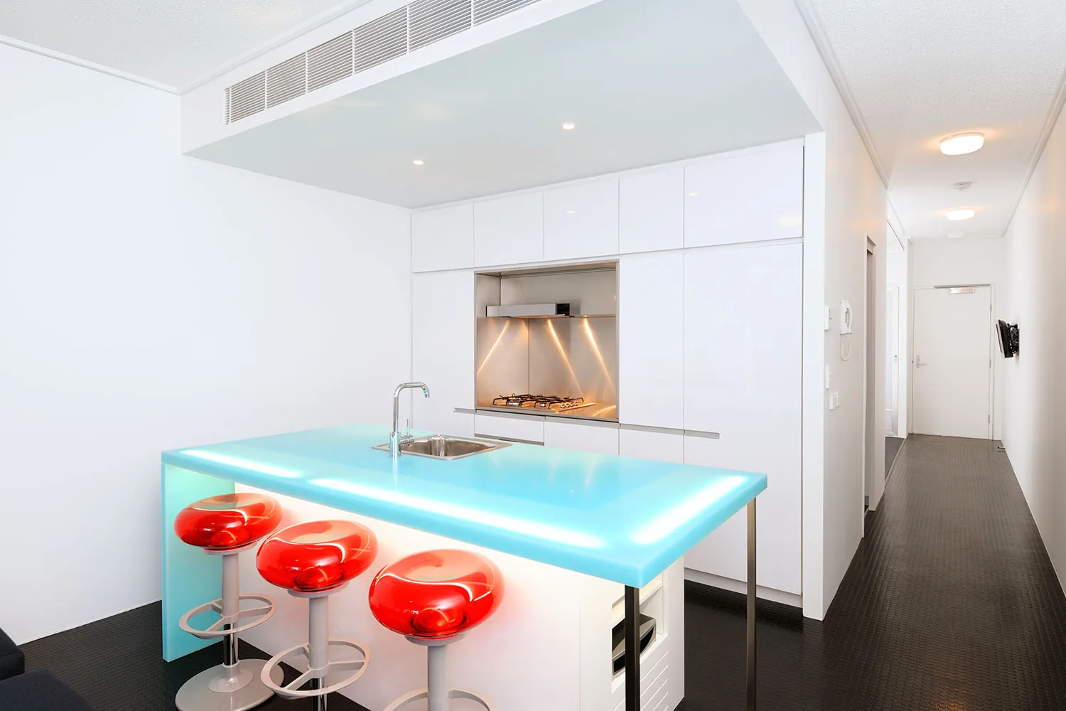 kitchen island with blue bench top and red chairs