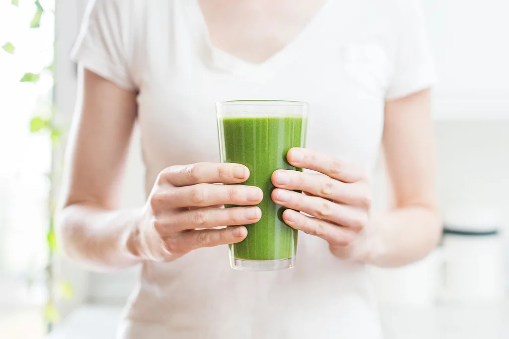 Woman holding green juice