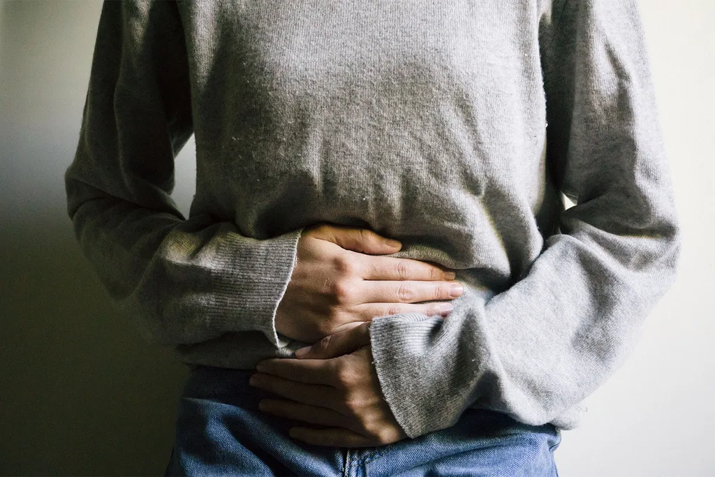 Woman holding abdominal area.