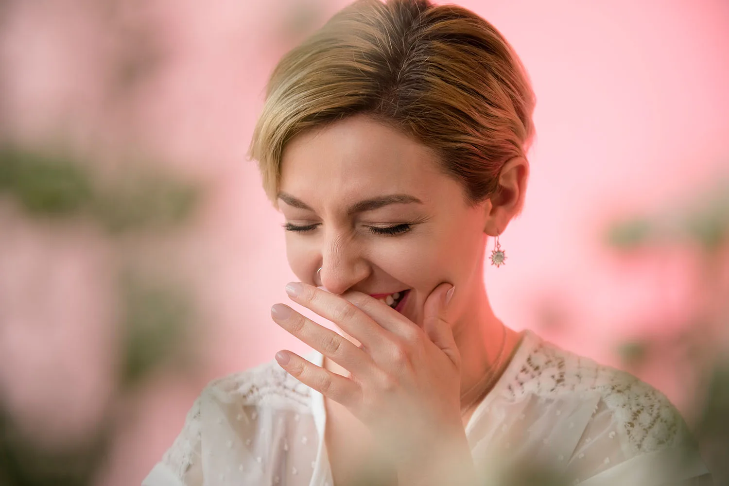 woman laughing holding hand in front of mouth