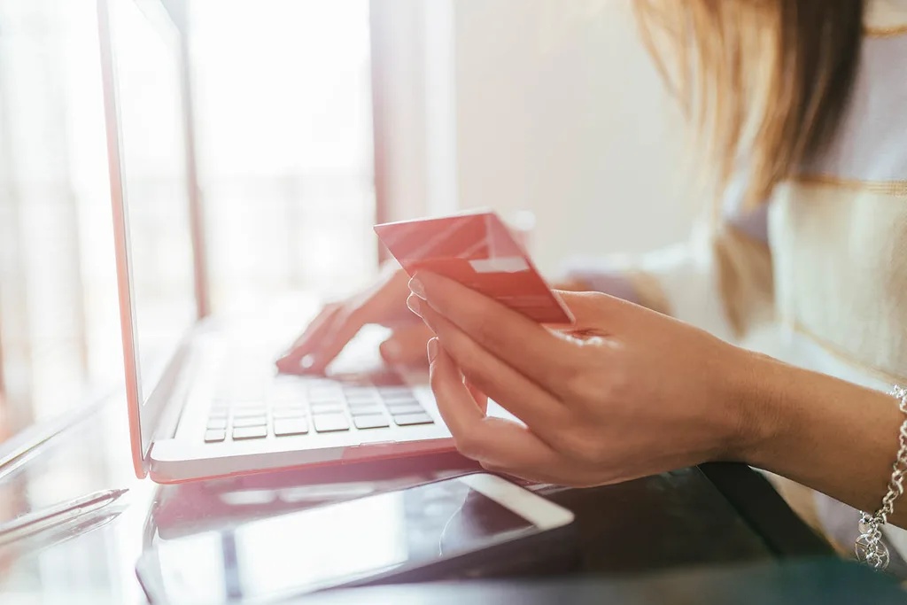 woman holding credit card and laptop