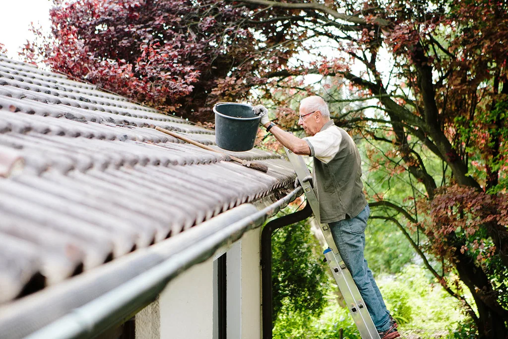 man clearing gutter